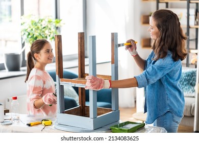 renovation, diy and home improvement concept - mother and daughter in gloves with paint roller and brush painting old wooden table in grey color at home - Powered by Shutterstock