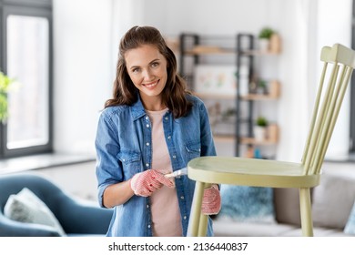 Renovation, Diy And Home Improvement Concept - Happy Smiling Woman In Gloves With Paint Brush Painting Old Wooden Chair In Grey Color