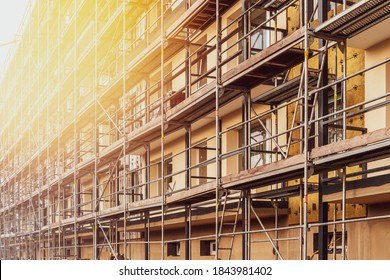 Renovation Of The Facade Of A Multistorey Building.Scaffolding Standing Against The Wall Of Tall Building.