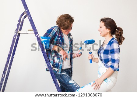 Renovation, redecoration and people concept - Portrait of couple stained with paint over white background