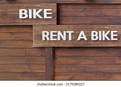 Rent A Bike Sign At Wooden Cabin Wall