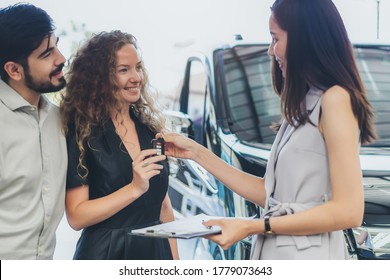 Rent a car business concept. Agent rental vehicles company giving a car key to client / customer in office after explain agreement document and term of used to lender.