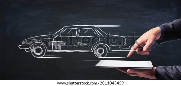 Rent a car and car sharing concept with painted\
car icon on dark background with businessman hands using digital\
tablet