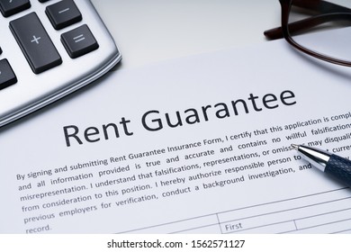 Rent Guarantee Form With Calculator, Pen, Spectacles Over Desk