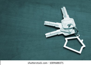 Rent House Concept With Keys On Key Holder On Brown Table