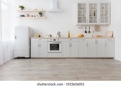 Rent of modern housing sale of new apartment, modern renovation. White furniture with utensils, shelves with crockery and plants in pots, refrigerator in simple minimal dining room, empty space - Shutterstock ID 1923656051