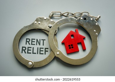 Rent Relief Concept. Handcuffs And Model Of House.