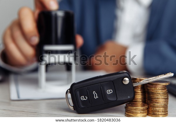 Rental agreement for a car with contract,\
stamp and key close-up. Concept for rental\
car