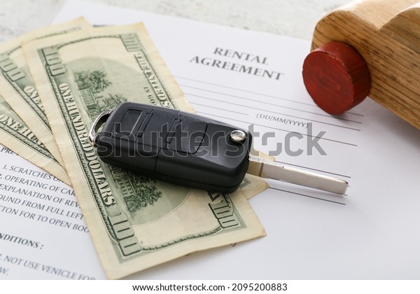 Rental\
agreement, wooden car, money and car key,\
closeup
