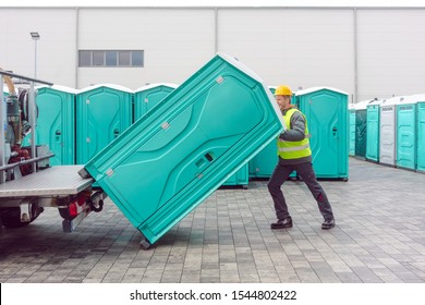 Rental lavatory being loaded on truck by worker