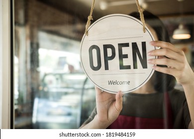 Reopen. waitress woman turning open sign board reopen after coronavirus quarantine is over in modern cafe coffee shop ready to service, cafe restaurant, small business owner, food and drink concept - Powered by Shutterstock