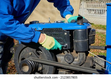 repair of agricultural machinery,man repairing a walking tractor, unscrewing the tractor nuts