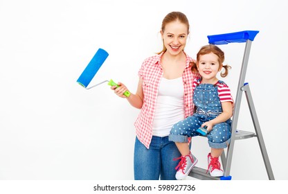 Repair In The Apartment. Happy Family Mother And Child Daughter  Paints The Wall With Blue Paint
