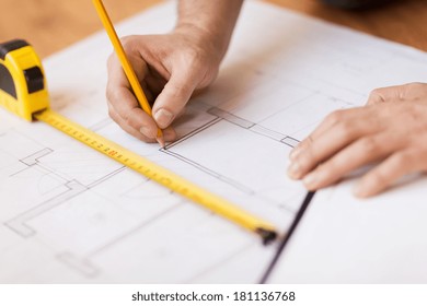 repair, building and home concept - close up of male hands making changes to blueprint - Powered by Shutterstock