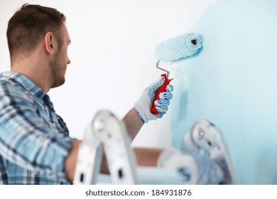 Repair, Building And Home Concept - Close Up Of Male In Gloves Holding Painting Roller