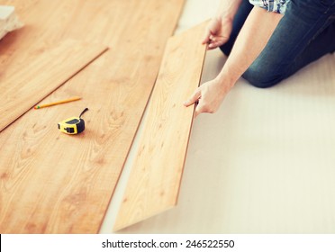 Repair, Building And Home Concept - Close Up Of Male Hands Intalling Wood Flooring