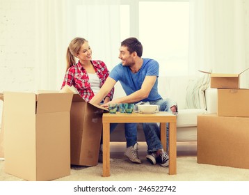 Repair, Building And Home Concept - Smiling Couple Unpacking Kitchenware