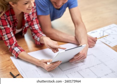 repair, building, renovation, architecture and technology concept - close up of couple with tablet pc and blueprint at home - Powered by Shutterstock