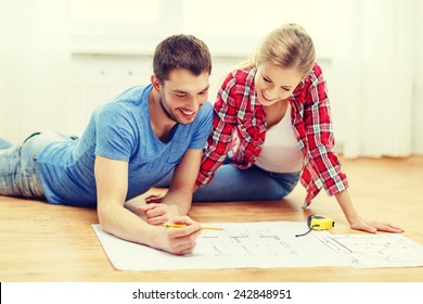 repair  building  renovation   home concept    smiling couple looking at blueprint at home