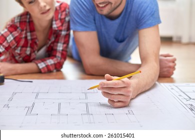 Repair, Building, Renovation And People Concept - Close Up Of Happy Couple Looking At Blueprint At Home