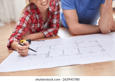 Repair, Building, Renovation And People Concept - Close Up Of Happy Couple Looking At Blueprint At Home