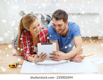 Repair, Building, Renovation, Technology And People Concept - Smiling Couple With Blueprint Looking At Tablet Pc At Home