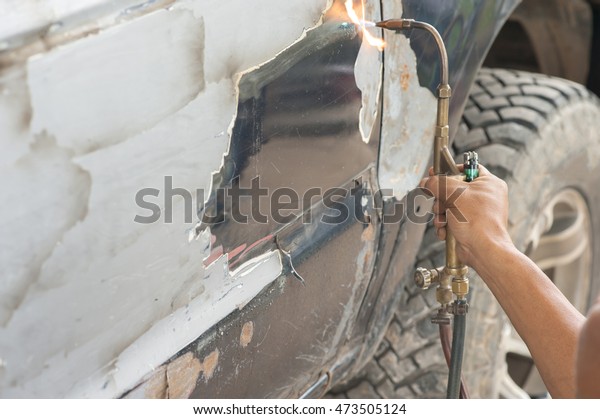 repair a car crash,\
close up car body worker