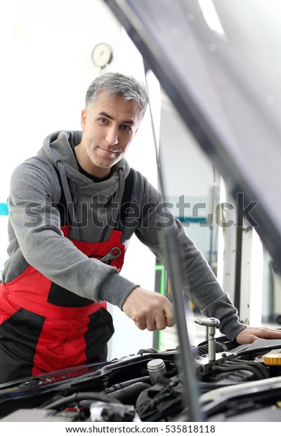 Repair the car, a man at work. Car mechanic working in a\
workshop 