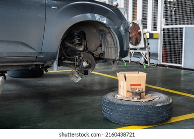 Repair And Change Parts A Pickup Truck With Damaged Axle And Wheel Lifted By Scissor Lift In Garage Workshop