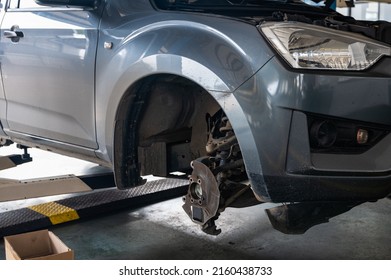 Repair And Change Parts A Pickup Truck With Damaged Axle And Wheel Lifted By Scissor Lift In Garage Workshop