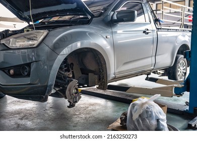 Repair And Change Parts A Pickup Truck With Damaged Axle And Wheel Lifted By Scissor Lift In Garage Workshop