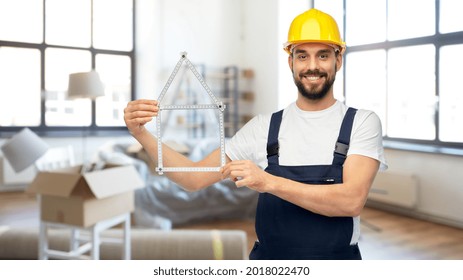 repair, construction and building concept - happy smiling male worker or builder in yellow helmet and overall with carpenter's rule in shape of house over home room background