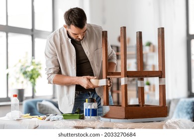 Repair, Diy And Home Improvement Concept - Man Sticking Adhesive Tape To Old Wooden Table For Repainting It