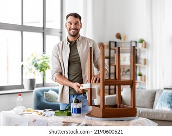 Repair, Diy And Home Improvement Concept - Happy Smiling Man Sticking Adhesive Tape To Old Wooden Table For Repainting It