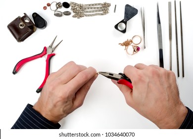 Repair Of Gold And Silver Jewelry. Hands Of The Jeweler With Tools And Jewellery Isolated On White Background.