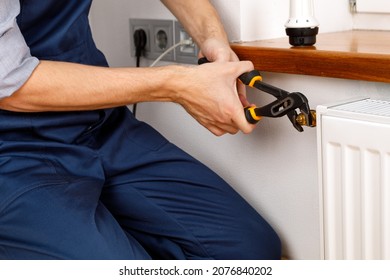 Repair Heating Radiator Close-up. Man Repairing Radiator With Wrench. Removing Air From The Radiator