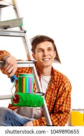 Repair Home Man Holding Paint Roller For Wallpaper. Tired And Frustrated Male In Newspaper Cap Renovation Apartment. Loan For Housing For Students. Stepladder In Foreground.