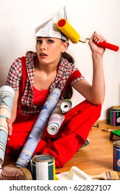 Repair Home Woman Holding Paint Roller For Wallpaper. Tired And Frustrated Female In Newspaper Cap Renovation Apartment. Paint Bank And Roll Paper Background On Isolated.