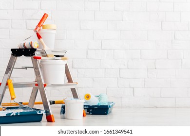 Repair, instruments and materials for painting walls, white bricks wall background, copy space