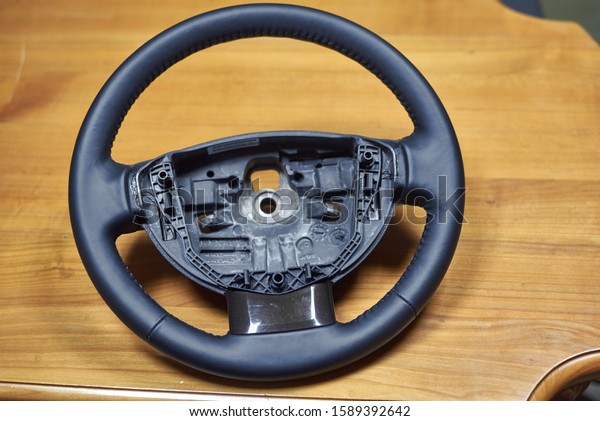 \
Repair of a\
leather car steering wheel in an auto repair shop on an old table.\
\
Disassembling the steering\
wheel