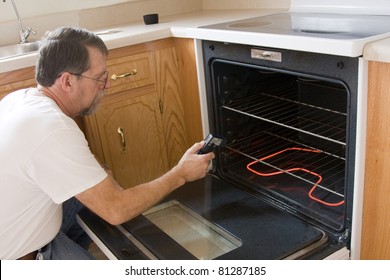 Repair Man Testing The Operation Of Stove & Oven