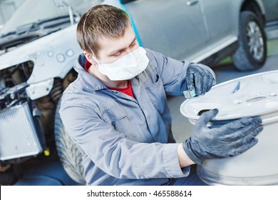 repair mechanic worker with light alloy car wheel disk rim