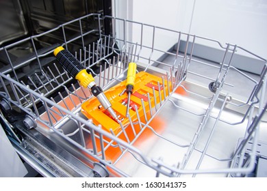 Repair Of A Modern Dishwasher With Screwdrivers In The Kitchen