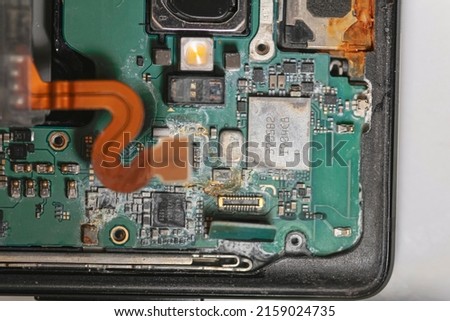 repair phone. rust on chip. microchip after water. computer hard drive. closeup of electronic part of phone circuit board. dust part of phone. repair microship on phone. dust and rust on metal part.