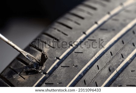 Repair plug being inserted to patch a nail tire puncture