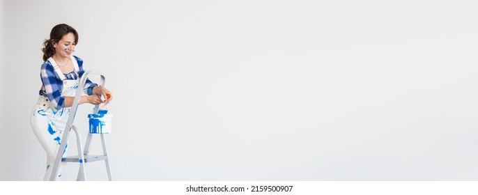 Repair, Renovation, Worker And People Concept - Beautiful Woman Standing On The Ladder And Mixing Paint Banner White Background With Copy Space And Empty Place For Advertising