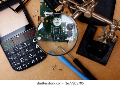 Repair Retro Phone Under Magnifying Glass On Wooden Table Top View