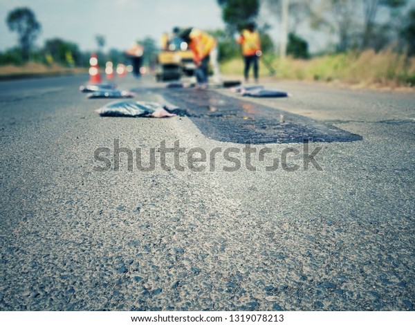 Repair of road maintenance by using asphaltic\
concrete, photo blurred