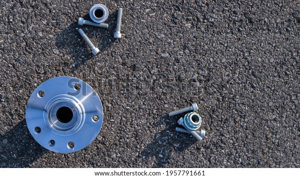 Repair service. Auto motor\
mechanic spare or automotive piece on dark road asphalt background.\
Set of new metal car part. Black bituminous textured\
waterproofing