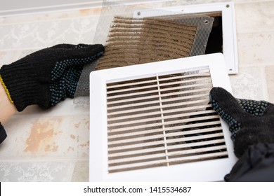 Repair Service Man Removing A Dirty Air Filter On A House So He Can Replace It With A New Clean. Extremely Dirty And Dusty White Plastic Ventilation Air Grille At Home Close Up, Harmful For Health 